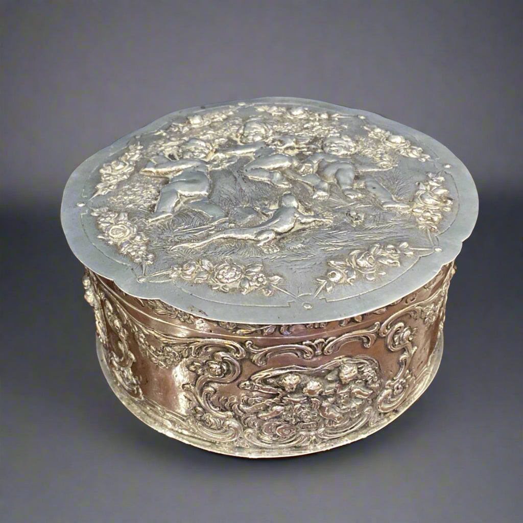 Silver biscuit box with Reynolds angels repousee design and gilt interior circa 1900