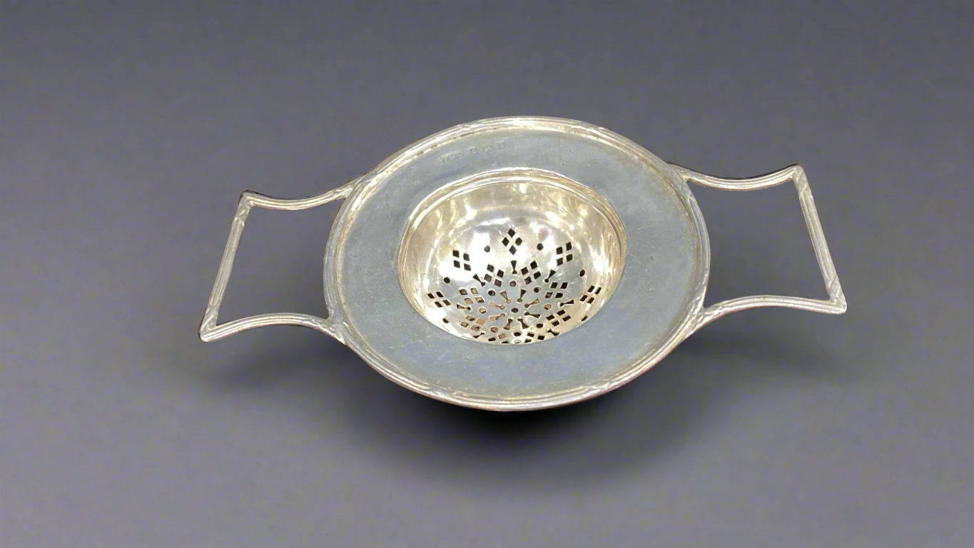 Silver tea strainer with large supporting lugs made in Birmingham 1908 by T Hardwood and Son