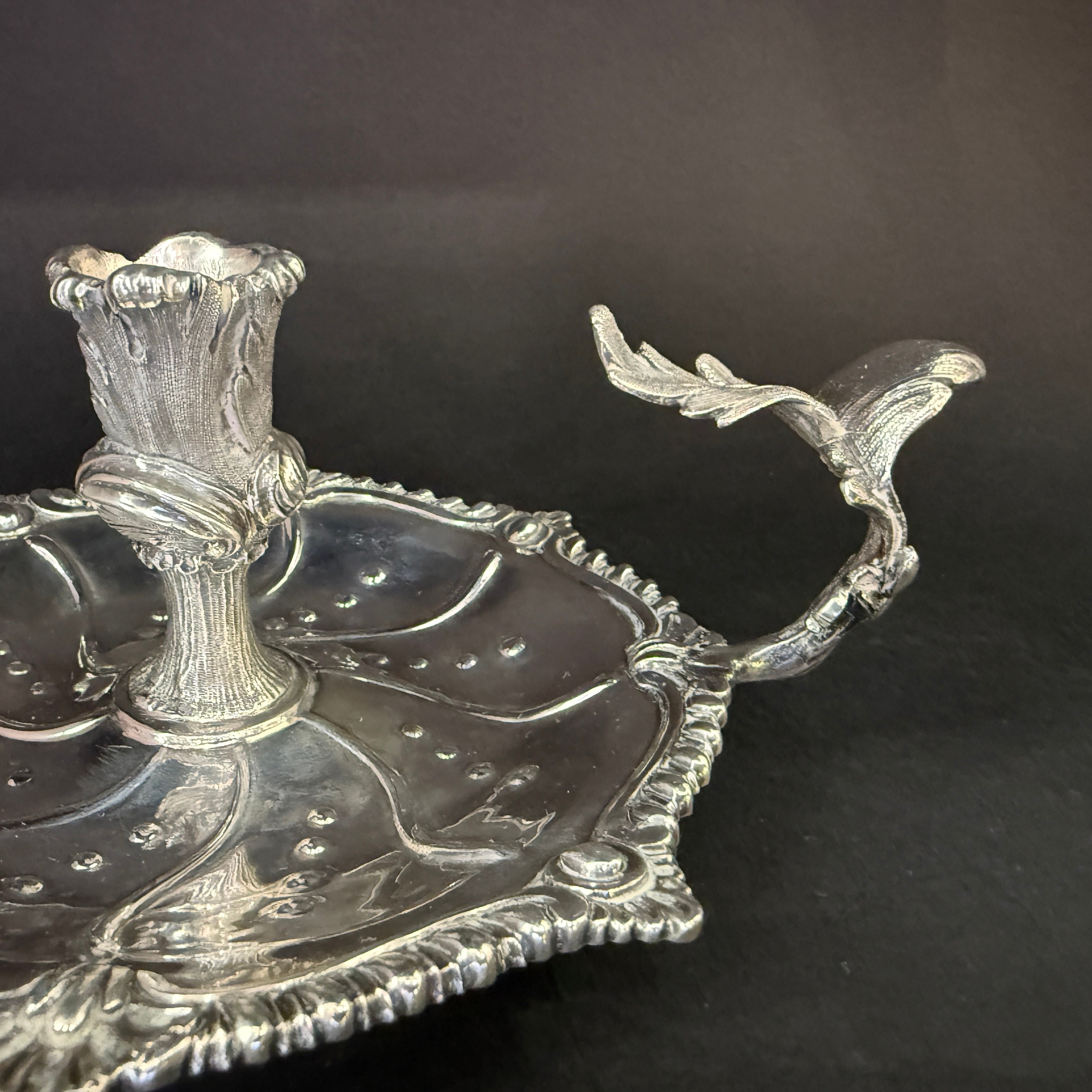 Silver chamberstick of lobed form with gadrooned shell work border and cast oak leaf carrying handle made in London 1949 by Henry Holland 
