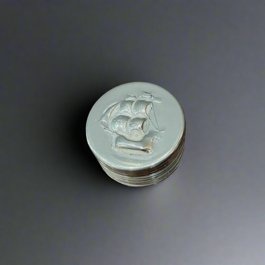 silver pill box with ship motif