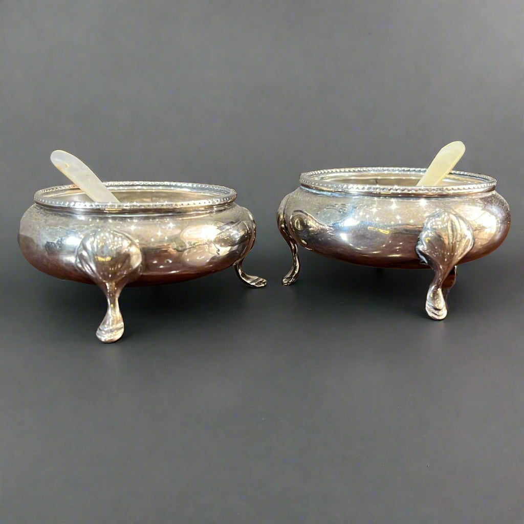 pair of silver salts with spoons