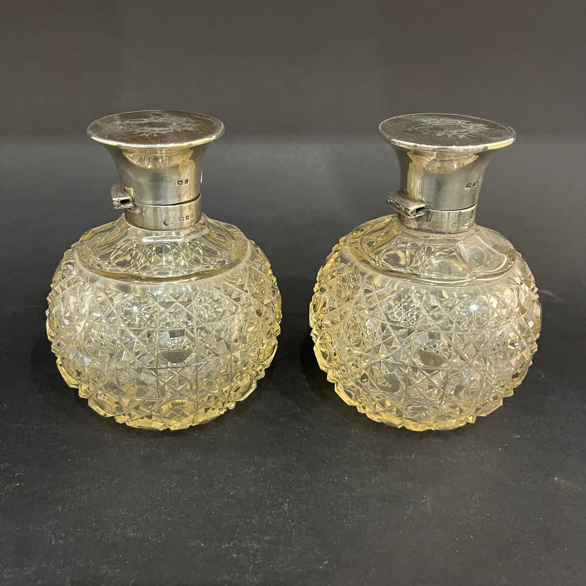 Pair of cut glass, silver and pique-work scent bottles made in London in 1920