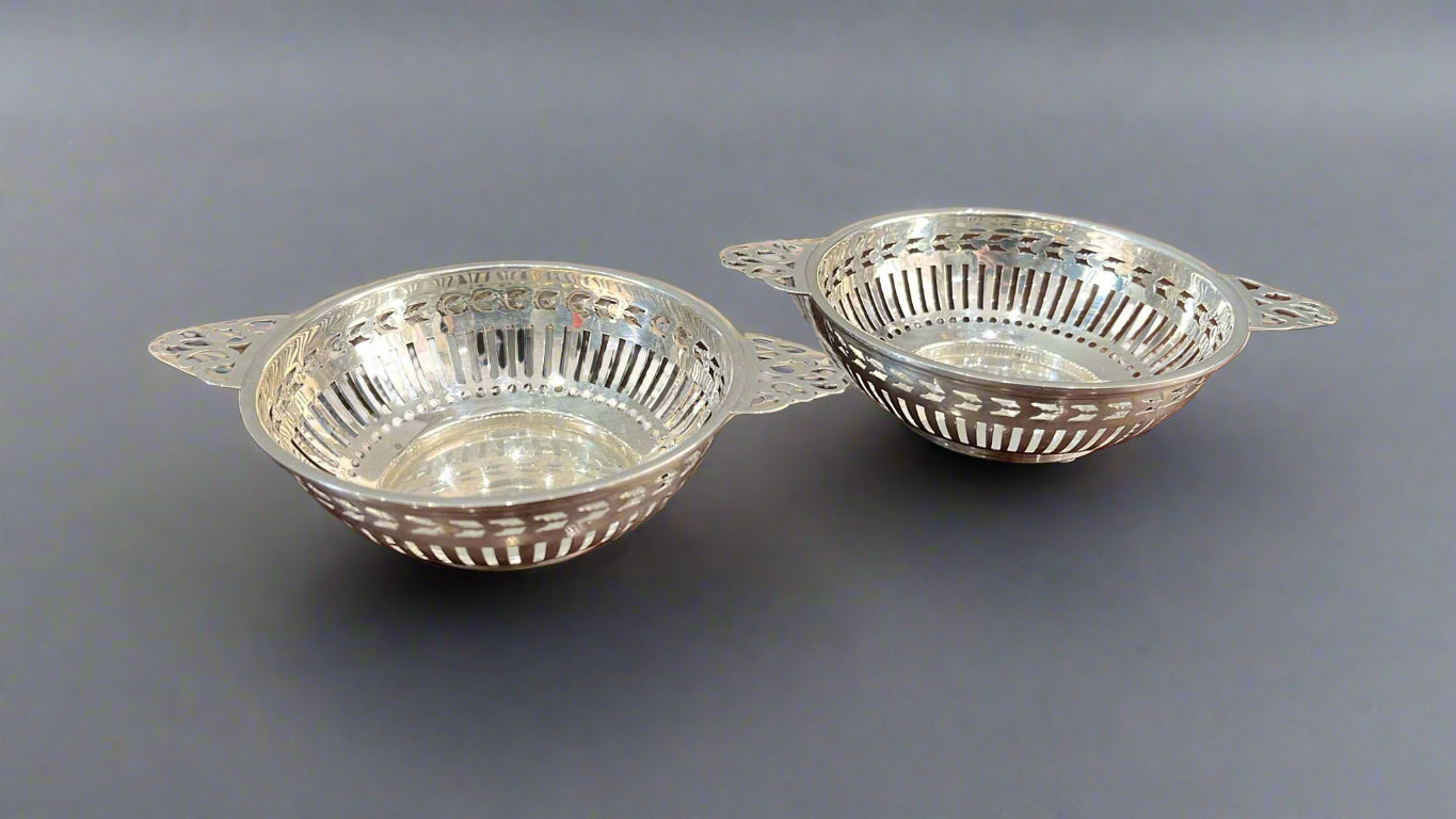 Pair of geometric pierced silver baskets with lug handles